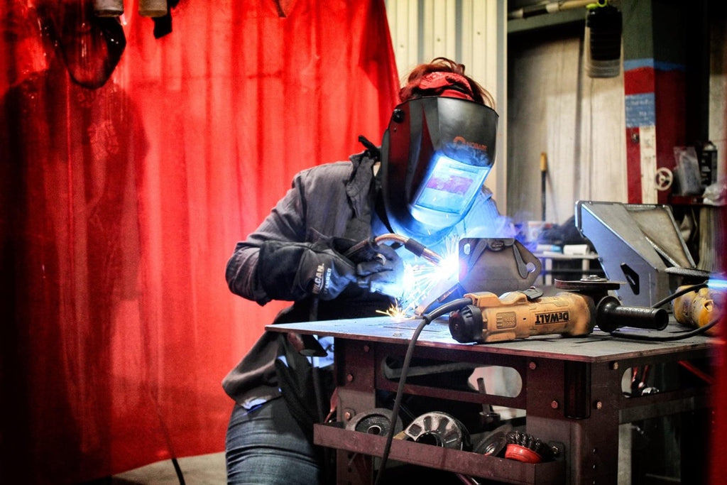 KRAZO team member welding a metal assembly at a worktable